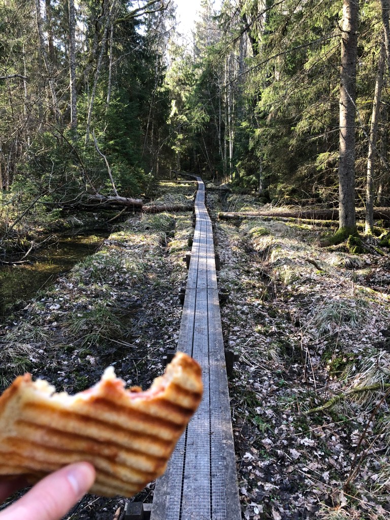 Spångad vandringsled med en varm macka i handen.
