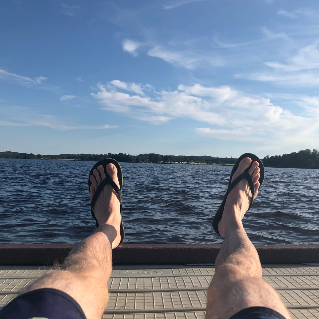 Bild från Hagabadets brygga över sjön och blå himmel med lätta moln