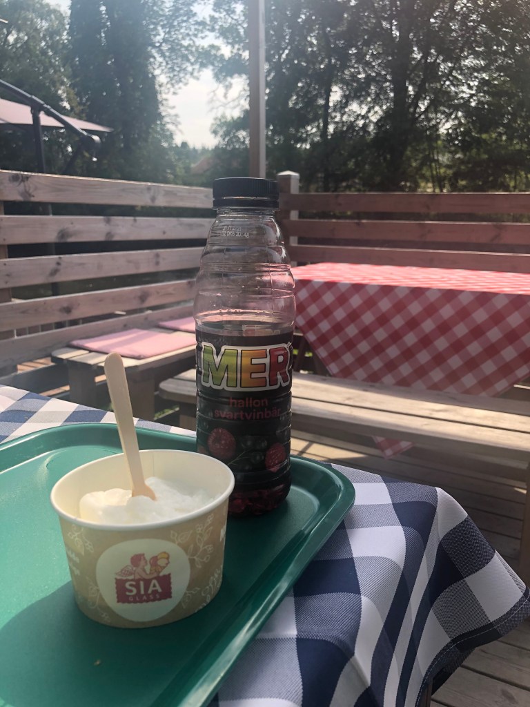 En kula citronsorbet i bägare och en mer i skuggan på uteserveringen av ett café.