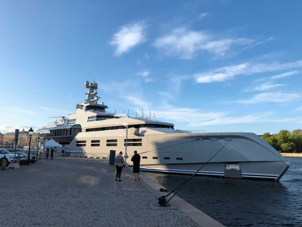 En gigantisk lyxjakt i grått, förtöjd i Stockholms ström.